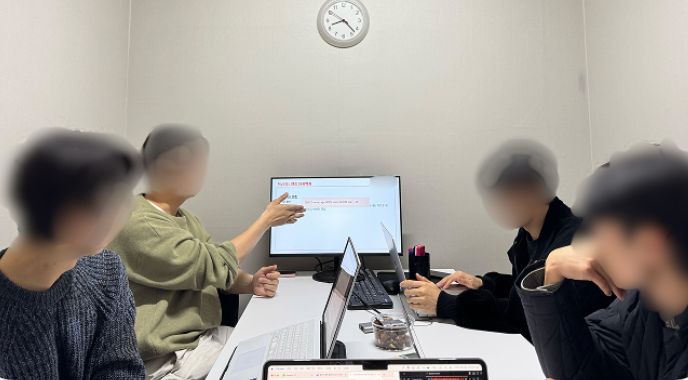 회의실에서 화면에 띄운 이력서를 함께 보며 이야기하는 모습